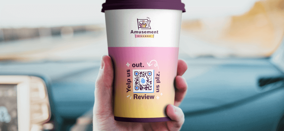 A hand holding a colorful coffee cup showcasing a Yelp QR Code.